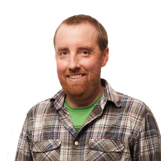 Headshot of Luke wearing a plaid flannel shirt